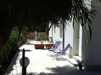 two blue chairs sitting on a patio next to a building at Casa Vacanze Mari in San Vito lo Capo