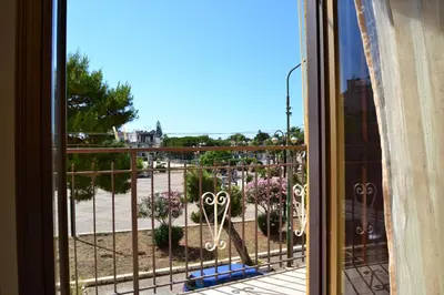 a window with a view of a garden with flowers at Casa Vacanze Laura in Isola delle Femmine