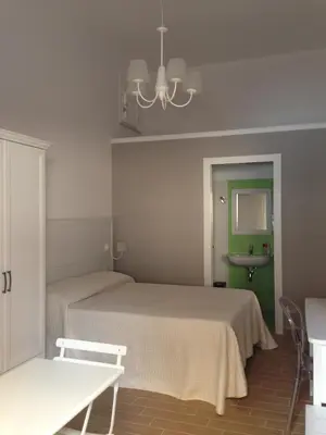 a bedroom with two beds and a green wall at Residenza Le Zagare in Castellammare del Golfo