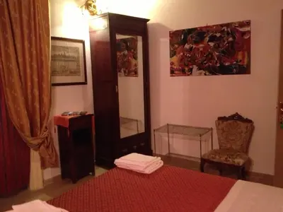 a bedroom with a bed and a mirror and a chair at B&B Domus Dei Cocchieri in Palermo