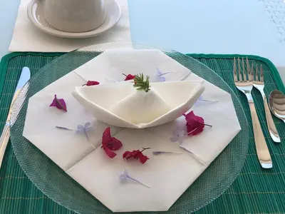a plate with a bowl and flowers on it at Blue Island Villa Caterina in Casteldaccia