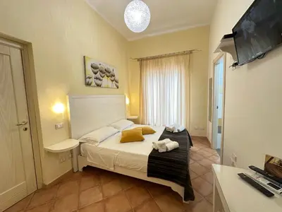 a bedroom with a bed and a flat screen tv at Badia Rooms & Breakfast in Castellammare del Golfo