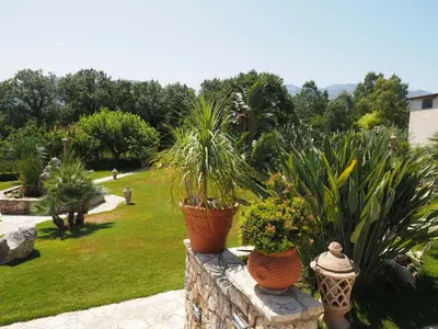 a garden with potted plants on a stone wall at B&B Al Giardino in Monreale