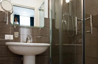 a bathroom with a sink and a glass shower at Operà in Palermo