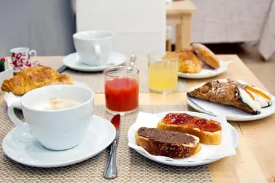 a table with plates of pastries and a cup of coffee at Operà in Palermo