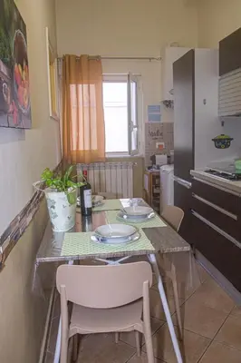 a kitchen with a table with chairs and a counter top at Casa Primavera in Palermo