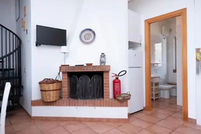 a living room with a fireplace and a tv at Casa Ponente con Vista Mare a Macari in Macari