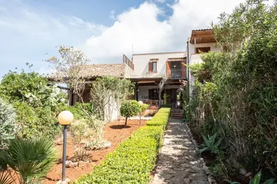 a house with a pathway leading to the front yard at Casa Ponente con Vista Mare a Macari in Macari