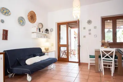 a living room with a blue couch and a table at Casa Ponente con Vista Mare a Macari in Macari