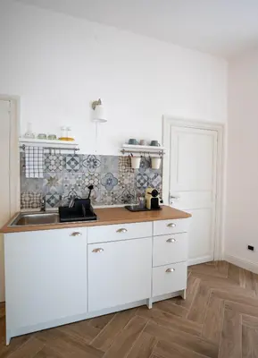 a kitchen with white cabinets and a sink at Casa Novelli Apartments in Monreale