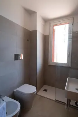 a bathroom with a toilet and a sink and a window at Residence Marinella in San Vito lo Capo
