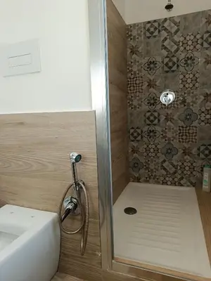 a bathroom with a shower with a sink and a toilet at Sicily Rooms Appartamenti in Carini