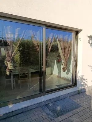 a sliding glass window with a reflection of a table at Sicily Rooms Appartamenti in Carini