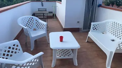 a white table and chairs with a red candle on it at Casa Rosina in Palermo