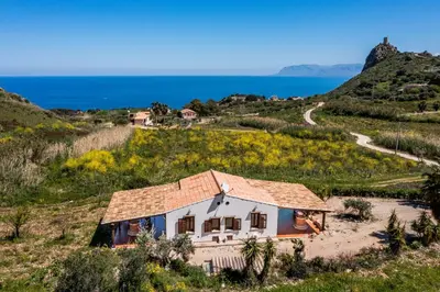 a house on a hill next to the ocean at Villa Elena vicino la Riserva naturale dello Zingaro in Scopello