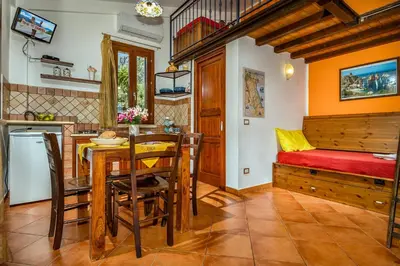 a kitchen and dining room with a table and a bed at Villa Elena vicino la Riserva naturale dello Zingaro in Scopello