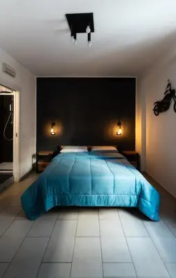 a bedroom with a blue bed and a black wall at Casa in centro in Palermo