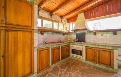 a large kitchen with wooden cabinets and a sink at Awesome Home In Trabia With Wifi in Trabia