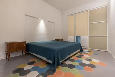 a bedroom with a bed and a dresser and a rug at Casa La Pomelia in Palermo