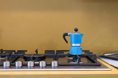 a blue coffee maker sitting on top of a stove at Casa La Pomelia in Palermo