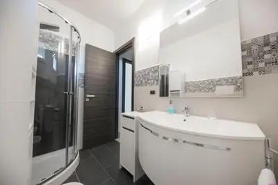 a white bathroom with a sink and a shower at Villa Francesca 30 Pax by Ville in Palermo in Casteldaccia