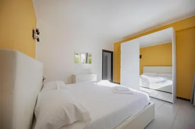 a bedroom with a white bed and a mirror at Appartamento 8 Pax in Villa Francesca by Ville in Palermo in Casteldaccia