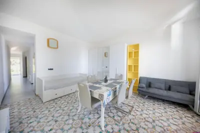 a living room with a table and a couch at Appartamento 16 Pax in Villa Francesca by Ville in Palermo in Casteldaccia