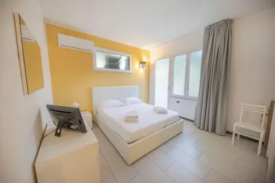 a bedroom with a bed and a desk with a television at Appartamento 16 Pax in Villa Francesca by Ville in Palermo in Casteldaccia