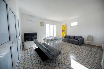a living room with a couch and a tv at Appartamento 23 Pax in Villa Francesca by Ville in Palermo in Casteldaccia