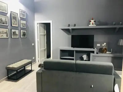 a living room with a couch and a tv at Home 3L in Palermo