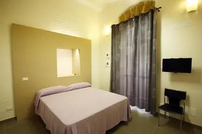 a bedroom with a bed and a television in it at Khalisah in Palermo