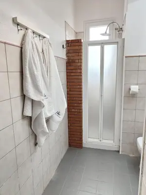 a bathroom with white towels hanging on a rack at Modern apartment with sea view in Alcamo Marina in Alcamo Marina