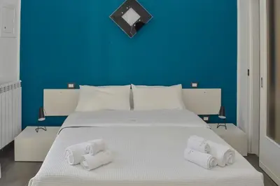a blue bedroom with a white bed with towels on it at Rooms 19 - Rooms and Breakfast in Palermo