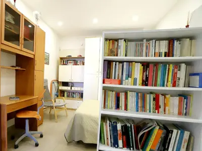 a room with several shelves filled with books at Plumeria/Libertà in Palermo