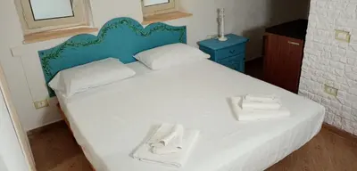 a bedroom with a white bed with two towels on it at Hostel Centro BASEMENT in Palermo