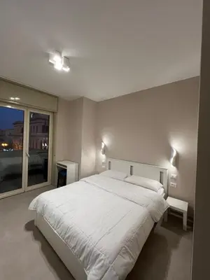 a bedroom with a large white bed and a window at CESARE ROOMS in Palermo