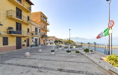 a street in a town with a flag and some buildings at La Casa Sul Mare in Trappeto