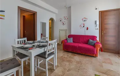a living room with a red couch and a table at La Casa Sul Mare in Trappeto