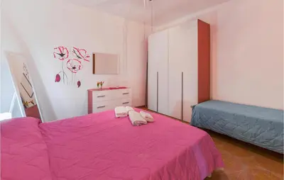a bedroom with a pink bed and a dresser at La Casa Sul Mare in Trappeto