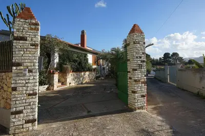 an entrance to a house with a brick pillar and a gate at Villa Caterina Scopello in Scopello