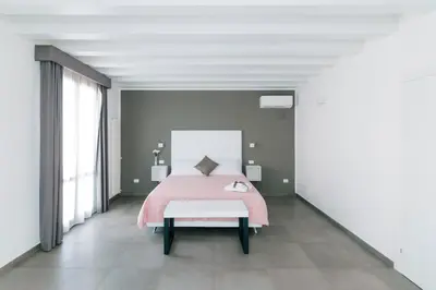 a bedroom with a pink bed and a bench at Boutique BnB Dolcevita in Palermo