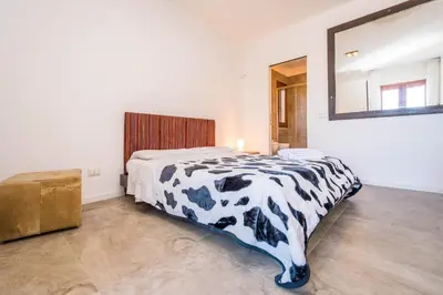a bedroom with a black and white bed and a mirror at B&B Le Dune - Self Check in in Lascari