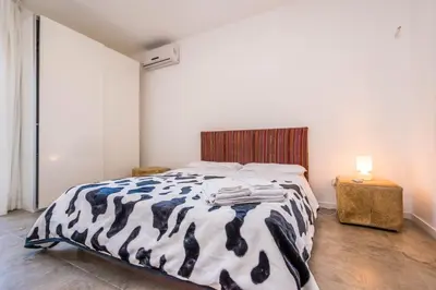a bedroom with a bed with a black and white comforter at B&B Le Dune - Self Check in in Lascari