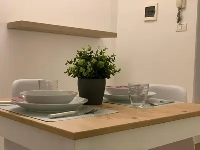 a table with bowls and plates and a plant on it at La Dimora della Cattedrale in Palermo