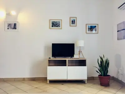 a living room with a tv on a white cabinet at La Dimora della Cattedrale in Palermo