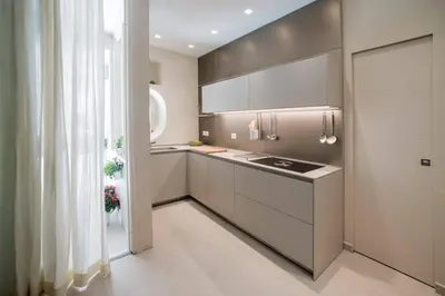 a kitchen with white cabinets and a sink and a window at One in Palermo