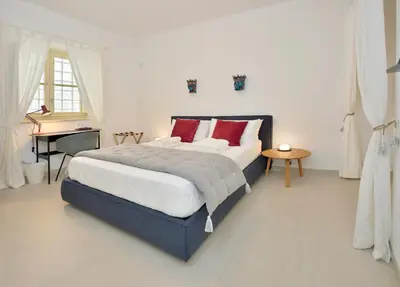 a bedroom with a large bed with red pillows at One in Palermo