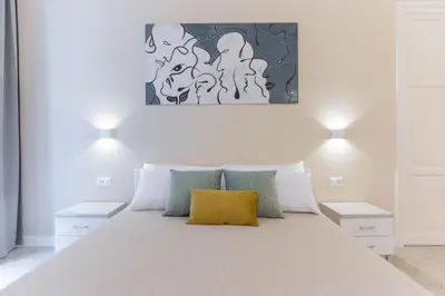 a bedroom with a white bed with a yellow pillow at Donna Isa B&B in Palermo