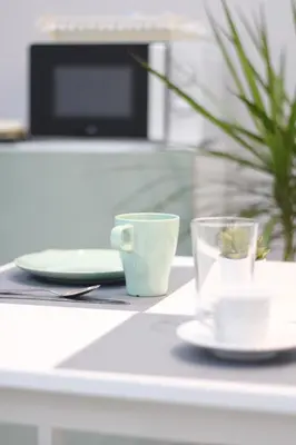 a table with two cups and plates and a plant at Solli Rooms in Palermo
