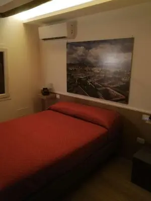 a bedroom with a red bed with a painting on the wall at San Francesco Rooms and Apartment with Terrace in Palermo Locazione Turistica in Palermo